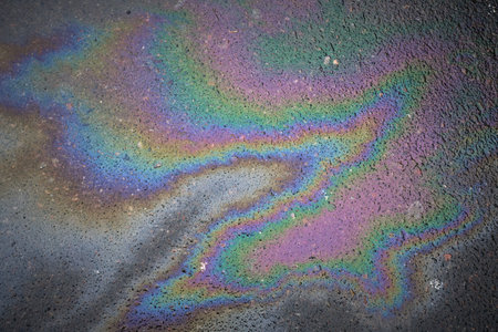 Textured stain of fuel or oil on wet asphalt on a rainy day.の写真素材