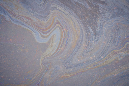 A marble texture of a rainbow spill of gasoline on a sidewalk in a puddle as a background.の写真素材