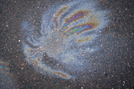 Slick industry oil fuel spilling ground pollution. Ground with patches of gasoline and oil.の写真素材