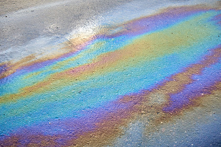 Slick industry oil fuel spilling ground pollution. Ground with patches of gasoline and oil.の写真素材