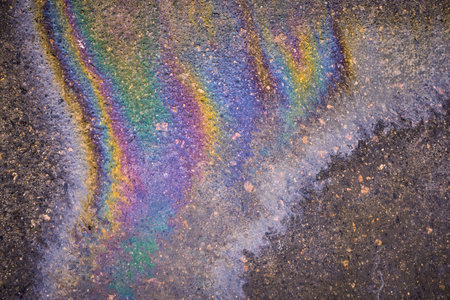 rainbow stripes on wet asphalt after fuel spill from carの写真素材