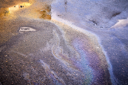 A colorful stain of engine oil on the roadの写真素材