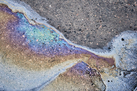 Color gasoline fuel spot on black asphalt, industrial pollution conceptの写真素材