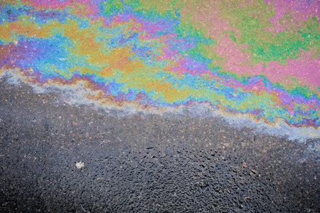 Color gasoline fuel spot on black asphalt, industrial pollution conceptの写真素材
