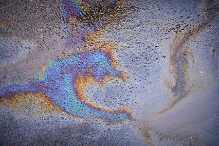 Oil rainbow gasoline spill on asphalt. Rainbow stains of oil and gasolineの写真素材