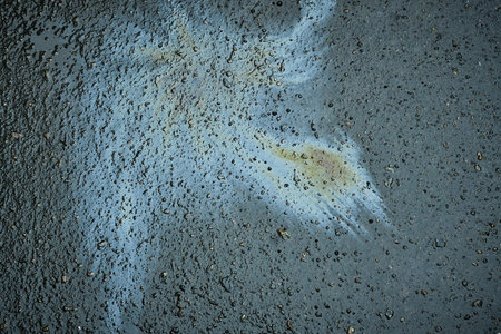 Oil stains from leaks in the car engine. Oil after rain makes spots with rainbow reflections refractive sun spectrumの写真素材