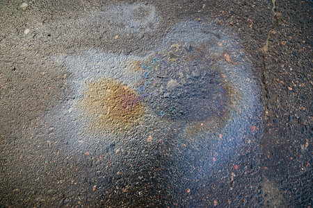 Brightly colored oil stain forming an abstract pattern on asphaltの写真素材