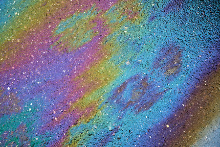 Colorful petroleum spill on asphalt, forming an artistic backdropの写真素材