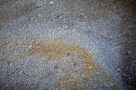 Perspective of bright petrol stains, displaying a textured ground with a range of colors on the streetの写真素材