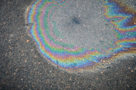 Vibrant rainbow oil spill on wet pavementの写真素材