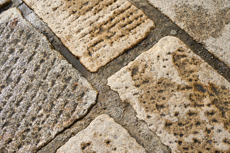 Historic Stone Pavement Revealing Textures and Patterns in a Well-Traveled Area During Daylight Hoursの写真素材