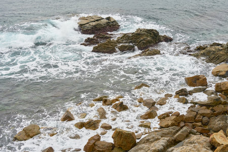 Waves Crash Against Rocky Shoreline Capturing the Essence of Coastal Beauty and Movementの写真素材