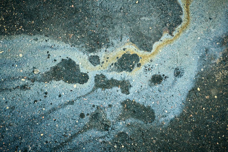 Oil Stain on Asphalt Showing Colorful Patterns After Rain in a City Street on a Cloudy Dayの写真素材