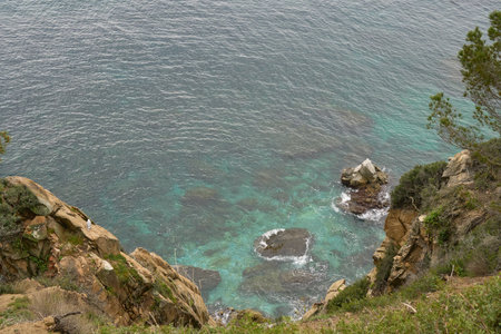 Coastal Cliff Overlooking Turquoise Waters With Rocky Formations During a Cloudy Dayの写真素材