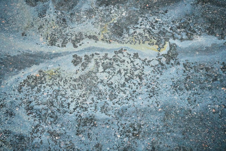 Abstract Texture of a Wet Surface Showing Intricate Patterns and Colors Captured Near a Waterway During Early Morning Lightの写真素材