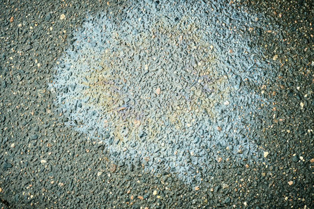 Colorful Oil Stain on Asphalt Road Surface Showcasing Textures and Patterns During Daylight Hoursの写真素材