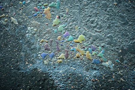 Colorful splashes of paint on the asphalt. Toned.