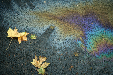 Oil spill creating vibrant rainbow colors on wet asphaltの写真素材