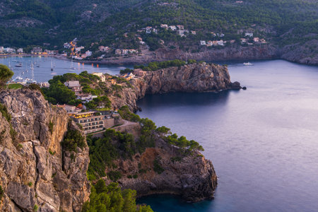 Beautiful sunset in coastal bay of Port de Soller. Yachts in harbor, houses, sea, everything was...