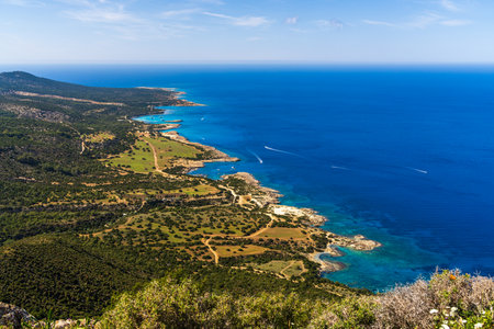 Breathtaking view of shoreline at Fountain of Amoros in Cyprus with boats floating on sea. Landscape with rocky shores, turquoise waters and serene marine activity in famous natural bay.の写真素材