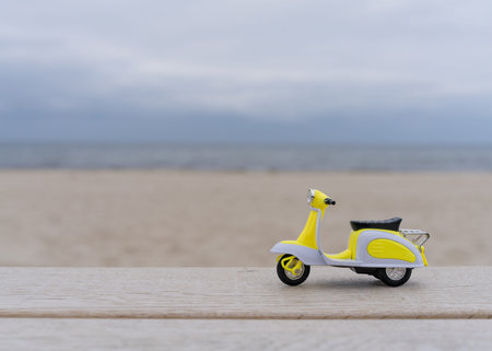 Still life. A small moped stands on a light tree against background of sea and white sand. Summer vacation. Postcard. Copy space.の写真素材