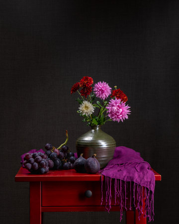 Variegated bouquet of autumn flowers. Dahlias. Dark background. Still life with flowers and grapes and fresh figs. Postcard. Holiday. Congratulations.の写真素材