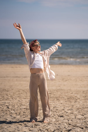 Happy, joyful girl enjoying time at sea. She raised her hands up. Vacation on Baltic Sea. Vacation...