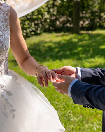 The groom puts the wedding ring on the bride at the wedding ceremony. Hand in hand. Wedding, holiday, engagement.の写真素材