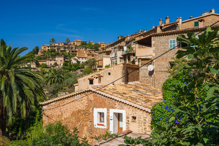 Stunning cityscape of the small coastal village of Deia in Mallorca, Spain. Traditional houses terraced on hills surrounded by green trees. Tourist destinations in Spain. Balearic Islands.の写真素材