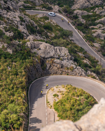 The Sa Calobra road in Mallorca, Spain, a favorite place for all cyclists. Lonely cyclists climb a winding roadの写真素材