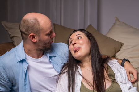Portrait of a cheerful and joyful couple. A man and a woman look at each other and stick out their...