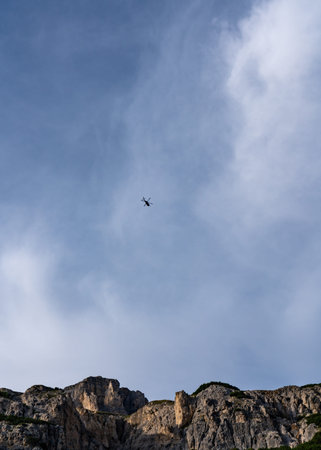 A helicopter flies against the blue sky. Dolomites, Italy, Alpsの写真素材