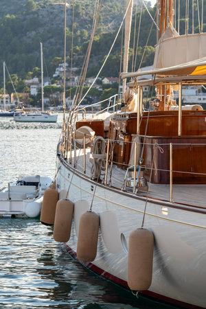 Sleek, luxury modern yacht docked in picturesque harbor of Port de Soller. Symbol of luxury and maritime elegance on Mediterranean coast. Mallorca, Balearic Islandsの写真素材