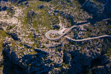 Stunning aerial shot of iconic Sa Calobra road winding through Tramuntana Mountains in Mallorca. Serpentine mountain pass, with sharp curves- top destination for travelers and cycling enthusiasts.の写真素材