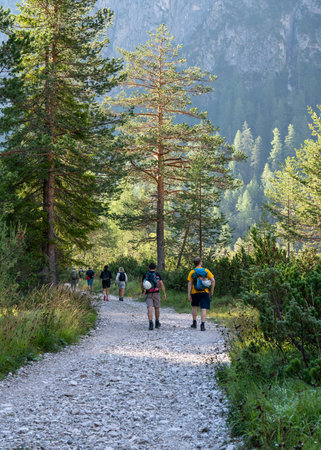 A group of tourists, climbers with backpacks go to the mountains early in the morning. Dawn in the Alps. Healthy, active lifestyle. Sports and pleasure. The joy of life. Beautiful nature. Rocks. Dolomiteの写真素材