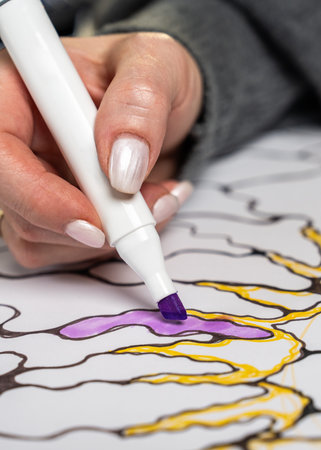 Close up of female hand drawing colorful shapes with marker on white paper. Creative hobby, self...