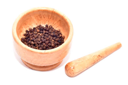 Mortar and pestle with black pepper seeds isolated on whiteの写真素材