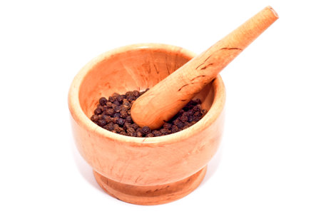 Mortar and pestle with black pepper seeds isolated on whiteの写真素材