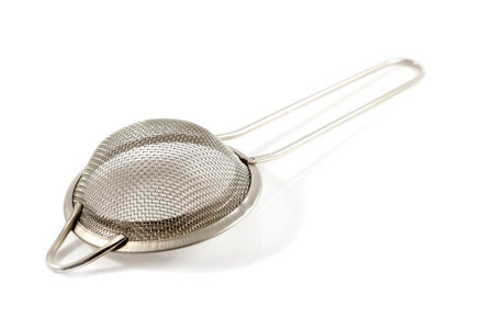 Metal sieve with a handle to separate the tea leaves on a white background
