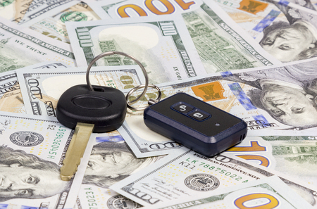 Car keys with remote control alarm located on the hundred dollar banknotesの写真素材