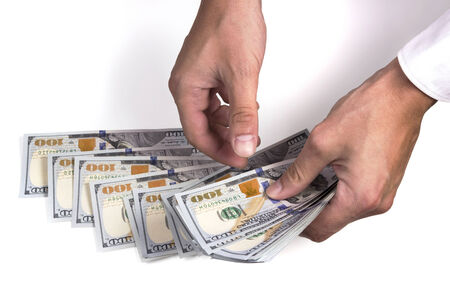 Close-up of a man hands counting dollar notes on white backgraundの写真素材