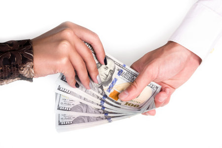 Man's hand passes a female hand hundred-dollar bills isolated on white background