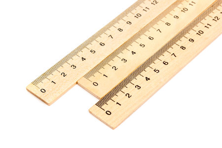 Three wooden ruler with millimeter divisions located near one another on a white background