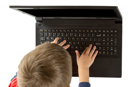 Small child touches the keyboard with your fingers open laptop top view isolated on white background