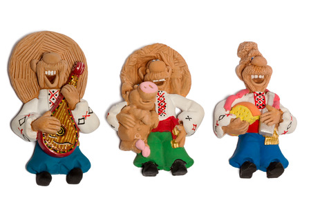 Clay figurine of three friends in embroidered shirts with the harp pig and cheese isolated on white backgroundの写真素材