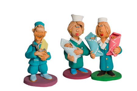 Clay statuette of three doctors with three babies on his hands isolated on white backgroundの写真素材