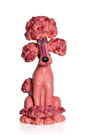 Pink ceramic figurine sad dog poodle isolated on a white backgroundの写真素材