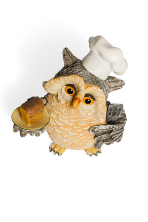Owl figurine cook in a nightcap with bread on the tray top view isolated on a white backgroundの写真素材