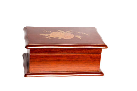 Closed retro wooden box casket with an ornament on the cover isolated on white backgroundの写真素材