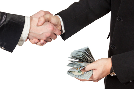 Men in suits handshake closeup with the money in the other hand single man isolated on a white backgroundの写真素材